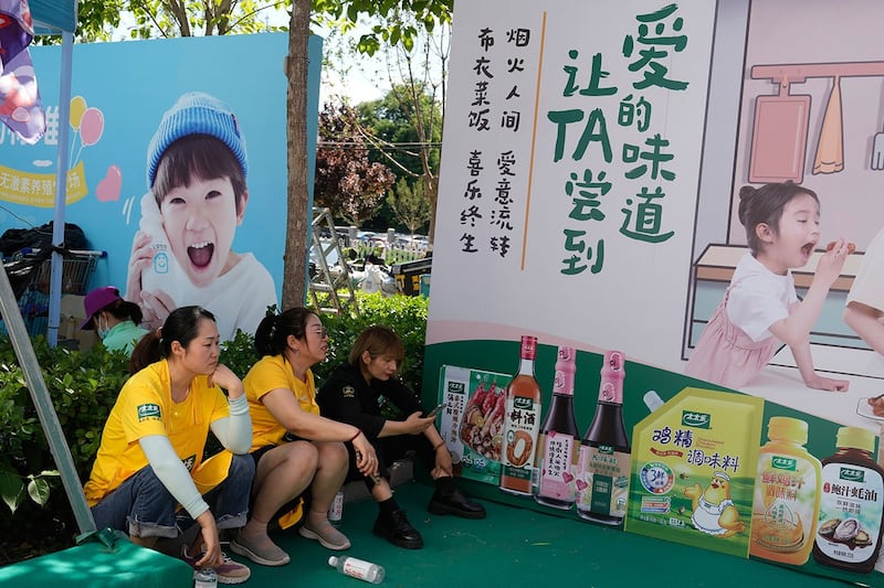 2024年5月31日,北京的一个露天市场的商贩正在休息,等待顾客。(美联社)