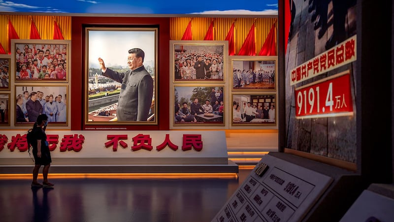 图为,在北京新落成的中国共产党博物馆,一名参观者走过展示习近平大型肖像的展览。 (路透社)