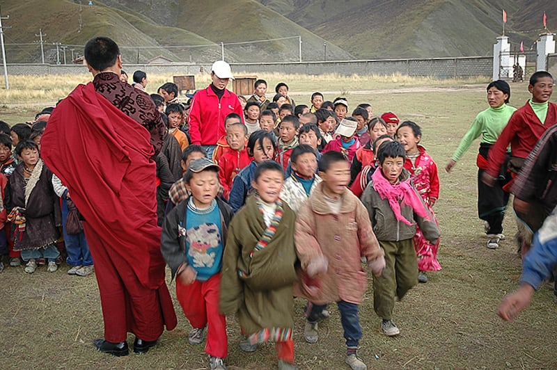 Tulku Hungkar Dorje is seen here, in an undated photo, with dozens of Tibetan children from nomadic families who were provided free education at a school he established.