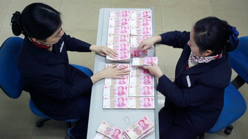 正在清点人民币的银行工作人员(路透社图片)