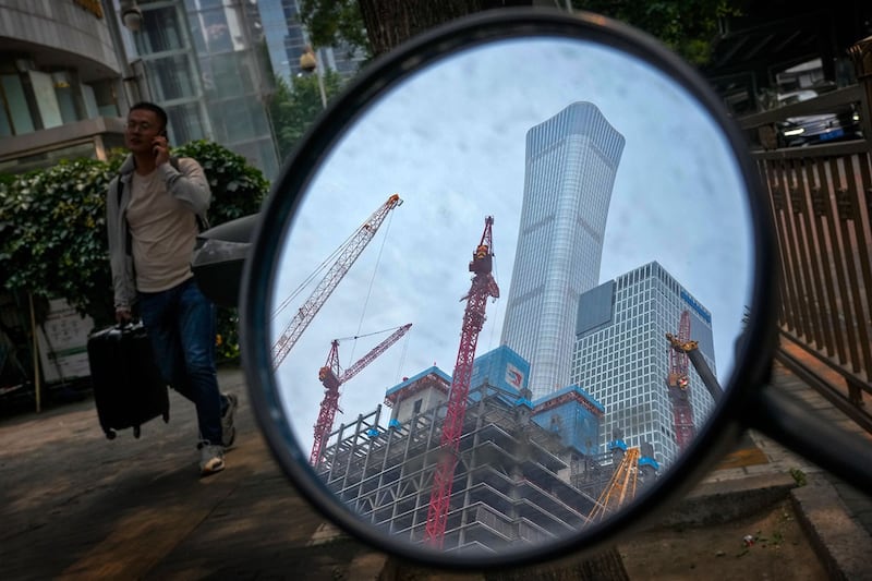 2024年6月5日,北京市中央商务区办公楼附近一辆电动滑板车的后视镜反射出的建筑工地。(美联社)