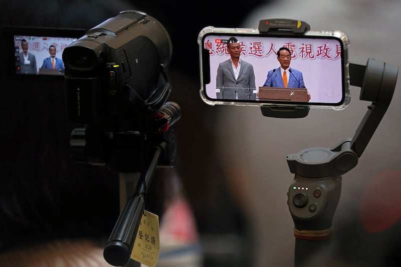 Members of the media use a mobile phone to live-stream the presser after the second live policy address ahead of January’s election in Taipei, Taiwan, Dec. 25, 2019.