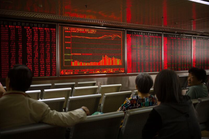 美国宣布加征关税后,中国和香港的股票市场不跌反升。图为2019年5月10日,市民在北京一经纪公司观看股票。(美联社)